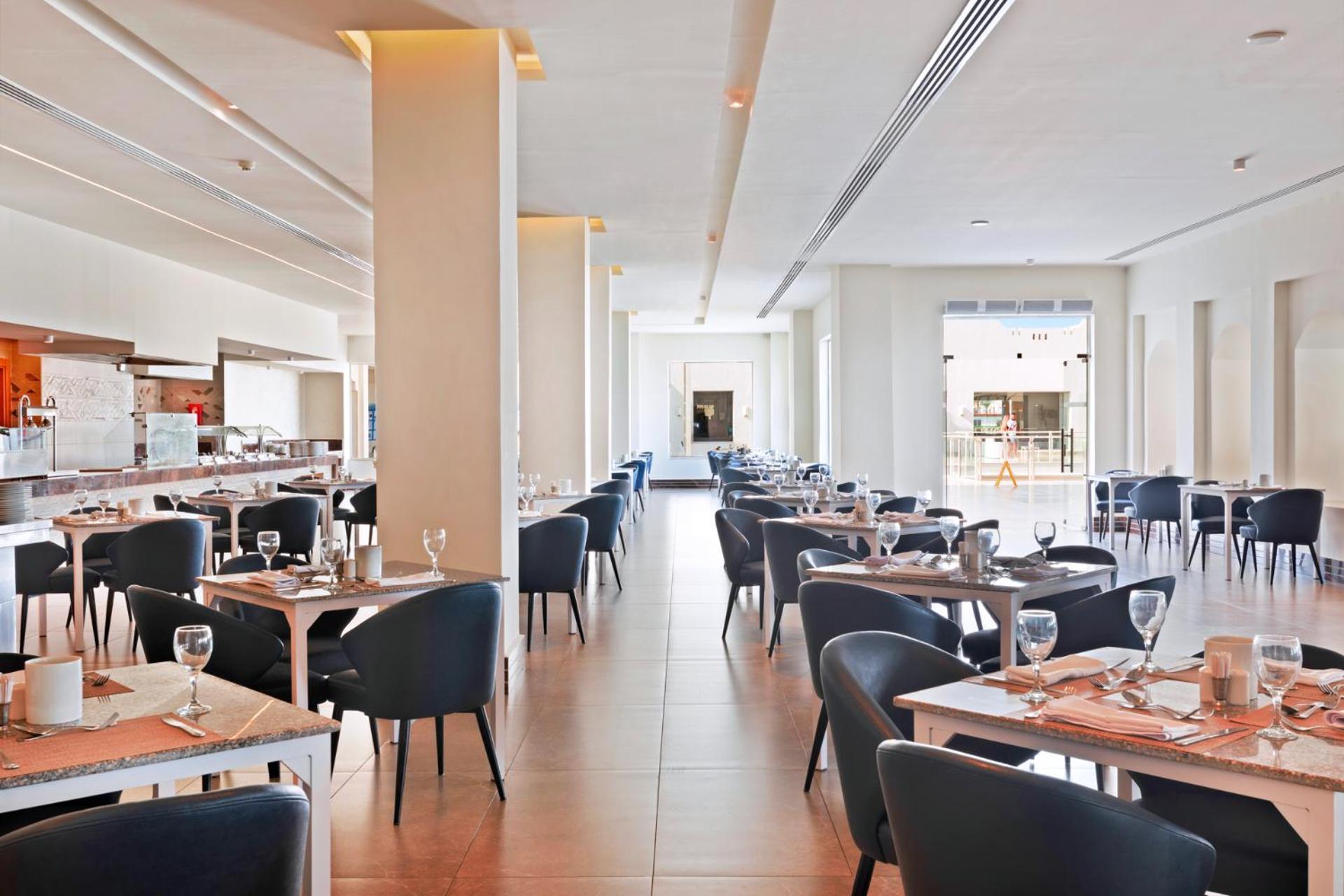 Pickalbatros Royal Grand Sharm - Adults Friendly 16 Years Plus Ngoại thất bức ảnh The photo shows the interior of a modern restaurant. The space is bright and airy, featuring large windows that allow natural light to flood in. There are several tables arranged throughout the room, each covered with placemats and set with glasses a